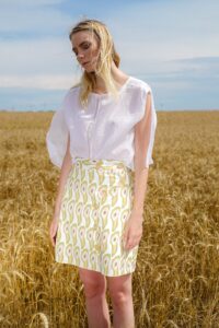 jeune femme souriante portant des vêtements écologiques avec fond de nature paisible