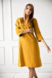 Vêtements en lin légers et confortables pour l'été avec une paire de sandales et un chapeau de paille sur fond neutre