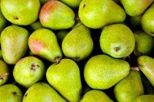 Poire mûre sur une table en bois avec feuilles d'automne en arrière-plan